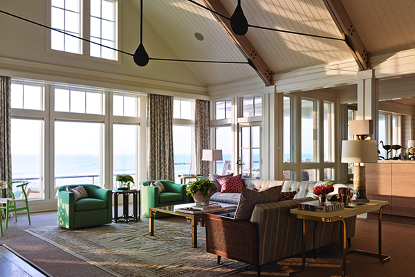 Vaulted ceiling living room with wall to wall Andersen windows overlooking the ocean. 